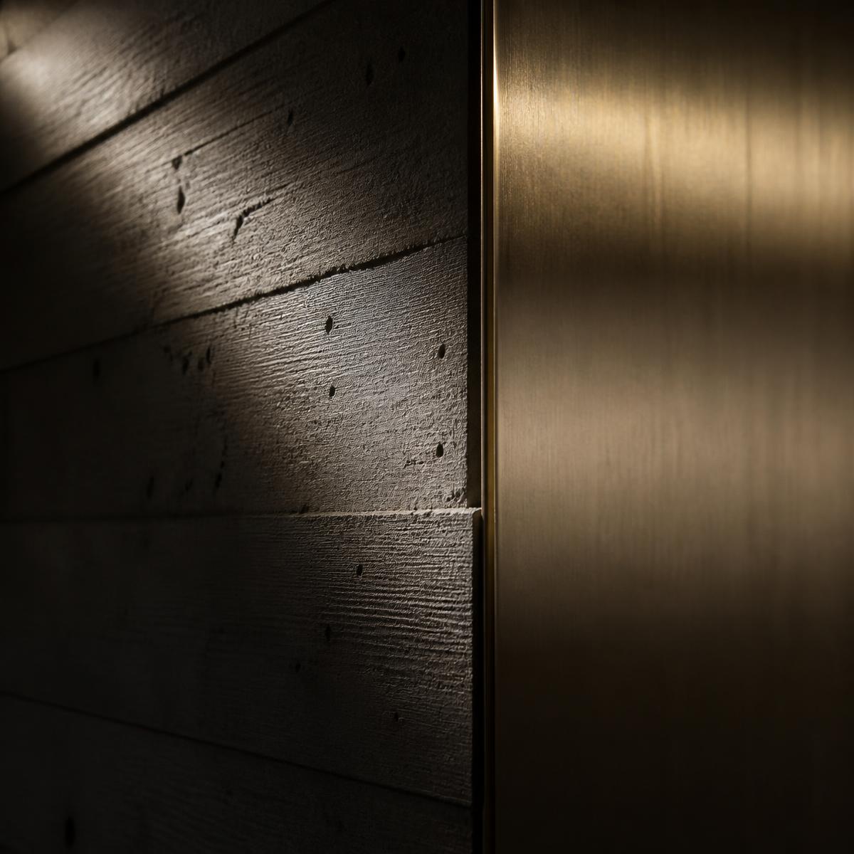 Board-formed concrete meeting brushed brass detail